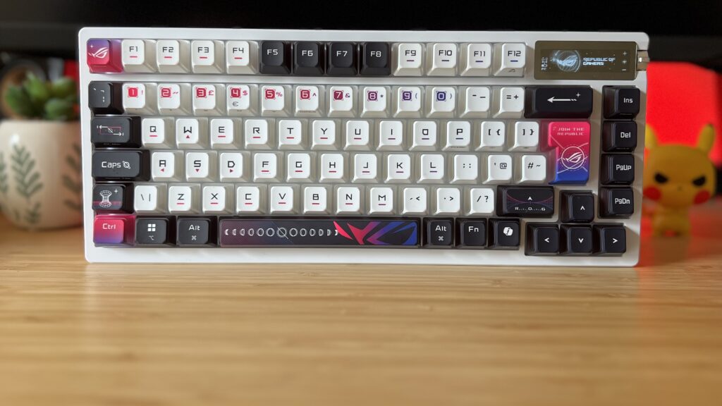 Asus ROG Azoth X gaming keyboard on a wooden desk with red backlighting